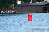 Red buoy in the harbour. Red sign in the docking area.