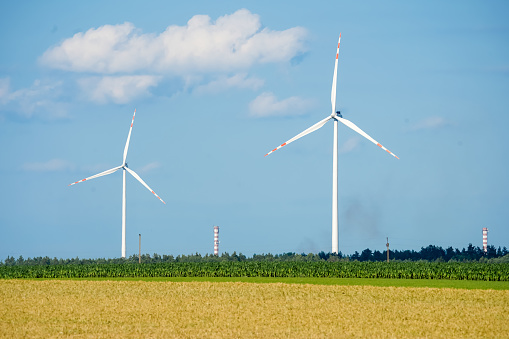 Aerial view on wind turbines on a levee and off the coast of Flevoland on the IJsselmeer coast in The Netherlands during a beautiful day with clouds in the sky.