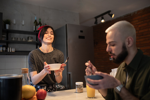 Young couple eating breakfast in the kitchen