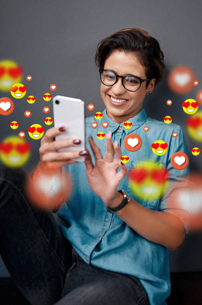 Smile, love emoji or happy woman with a phone for communication, social media texting or online dating. Graphic overlay or relaxed girl on mobile app website or digital network with heart emoticons Smile, love emoji or happy woman with a phone for communication, social media texting for online dating. Graphic overlay or relaxed girl on mobile app website or digital network with heart emoticons heart emoji phone stock pictures, royalty-free photos & images