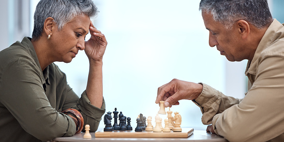 Strategy, moving and thinking with old couple and chess for bonding, competition and mental exercise. Relax, problem solving and smart with man and woman at home for board games, checkmate or contest