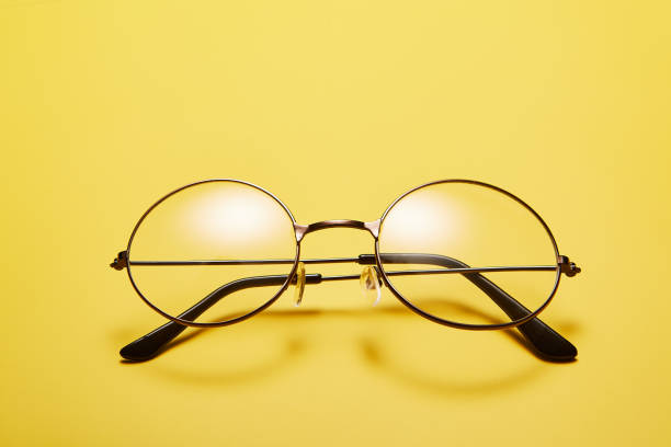 istock Open metal rimmed spectacles isolated on yellow, top view. 1511147726