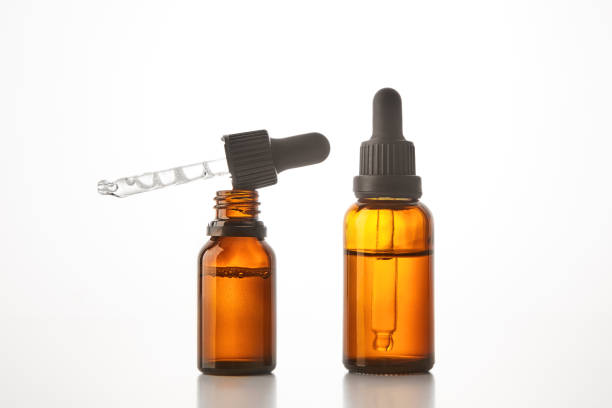 istock Two brown vials with black dropper caps isolated on white. 1511165503