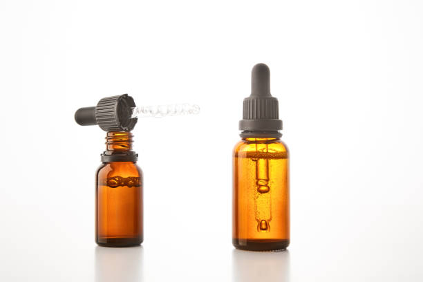 istock Two brown vials with black dropper caps isolated on white. 1511165516
