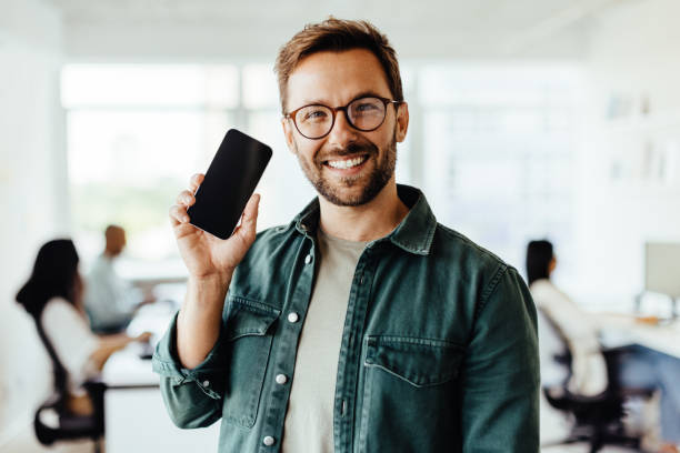 istock Business man recommending a mobile phone in an office 1511169368