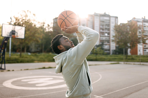 Man practicing basketball shooting alone