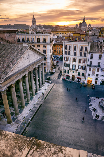 A sunset seen from a terrace in the historic center of Rome with the Roman Pantheon and Piazza della Rotonda in the foreground. Built in 27 BC by the Consul Marco Vispanio Agrippa for the emperor Augustus and dedicated to the Roman divinities, the majestic Pantheon is one of the best preserved Roman structures in the world. In 1980 the historic center of Rome was declared a World Heritage Site by Unesco. Wide angle image in high definition quality.