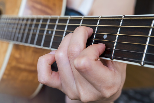 Close up of guitarist hand playing guitar. Chord Am.
