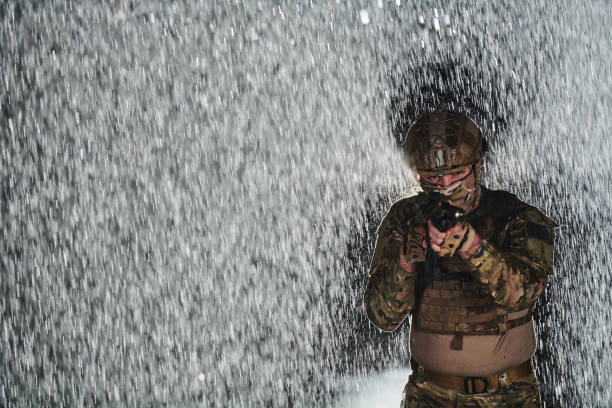 istock Army soldier in Combat Uniforms with an assault rifle, plate carrier and combat helmet going on a dangerous mission on a rainy night. 1511190864