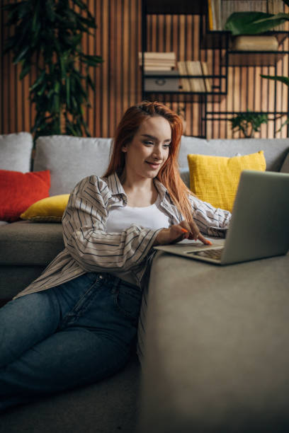 istock Redhead woman using laptop and relaxing at home 1511209856