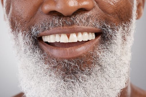 Mouth, teeth and beard with a senior man in studio on a gray background for beauty, skincare or grooming. Dentist, smile and happy with a person closeup for dental care, oral hygiene or whitening