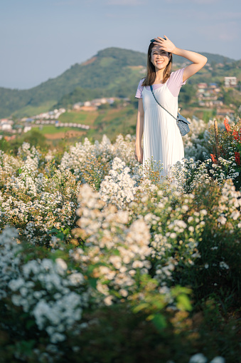 Asian happiness moment Nature lover standing in flower garden enjoy morning sunset nature garden background
