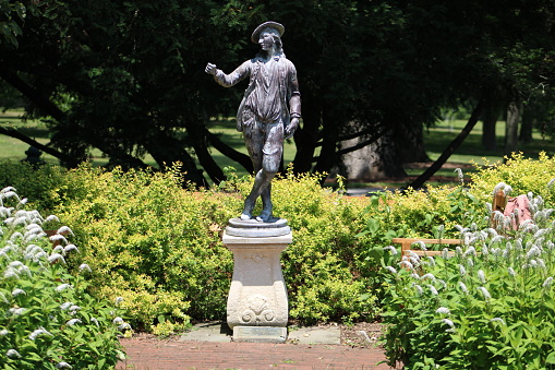 The statue in the flower bed in front of the famous mansion at the Bayard Cutting Arboretum state park.
