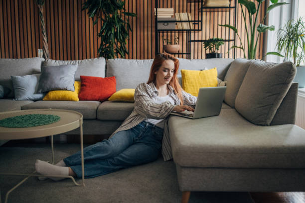 istock Redhead woman using laptop and relaxing at home 1511215991