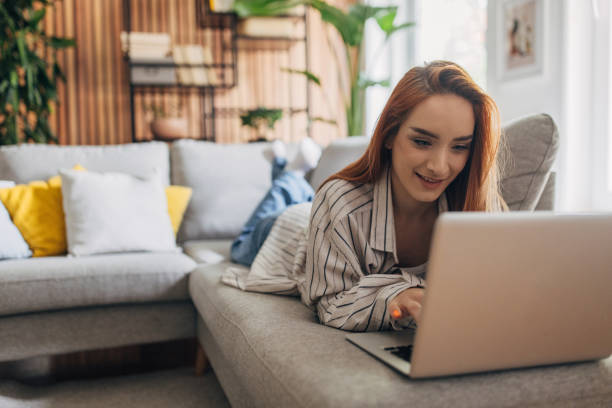 istock Redhead woman using laptop and relaxing at home 1511235518