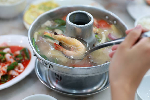 Top view of a clear tom yam soup with seafood
