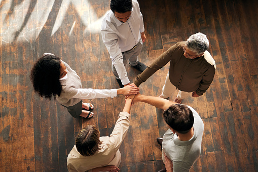 Teamwork, above and people hands stacked for support, collaboration and project mission for business startup. Group circle, women and men, together hand sign and community goals or career solidarity