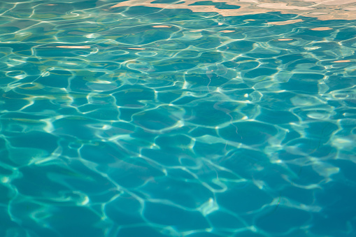 Close up of water in a swimming pool at a holiday rental in Toulouse, South of France. The water is reflecting sunlight on the surface.