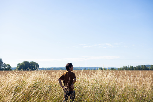 Man standing in a wheat field practising mindfulness while on vacation in Toulouse, South of France.