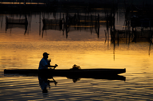 A Hispanic Man in His Forties Steers His Boat in the Columbia River in Washington on a Sunny Day
