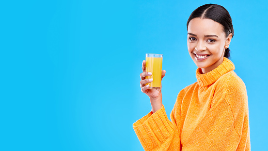 Orange juice, happy and portrait of woman in studio and mockup for nutrition, health and diet. Vitamin c, fruit and fresh with female drinking on blue background for citrus, fiber or organic beverage