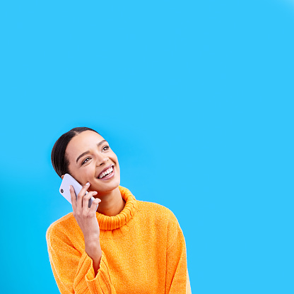 Laugh, mockup and woman on phone in studio with happiness and a smile from talk. Happy, isolated, and blue background and a young female and gen z model laughing on a mobile web conversation