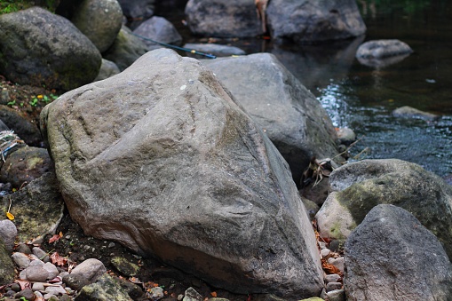 Crystal-clear water flow reveals rocks at the riverbed, showcasing the transparency of nature.