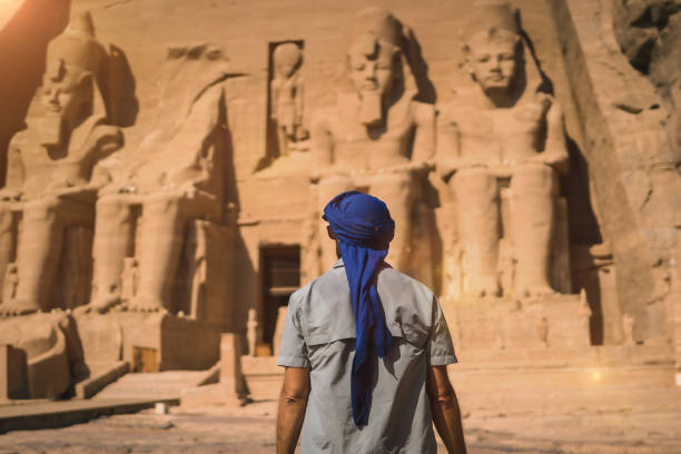 A young tourist with a blue turban visiting the Abu Simbel Temple in southern Egypt A young tourist in a blue turban looking at the Abu Simbel Temple in southern Egypt in Nubia next to Lake Nasser. Temple of Pharaoh Ramses II, travel lifestyle ramses i stock pictures, royalty-free photos & images