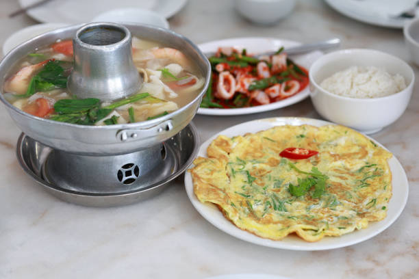 High angle view authentic Tom Yum Thai food with fragrant rice, fried egg and squids salad.