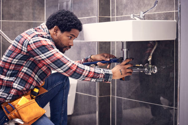Black man, plumber and maintenance in bathroom, fixing sink pipe with wrench and plumbing industry. Manual labor, male with focus and trade, handyman doing repairs with tools on home renovation hombre negro, fontanero y mantenimiento en baño, arreglando tubería de fregadero con llave inglesa e industria de plomería. trabajo manual, hombre con enfoque y oficio, personal de mantenimiento que hace reparaciones con herramientas en la renovación d