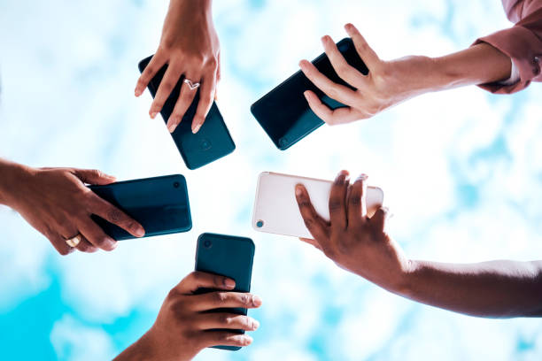 istock Connection, below and hands with phone on a blue sky for social network, communication and sharing. Bluetooth, friends and group with mobile for an app share, cloud computing and circle networking 1511332436