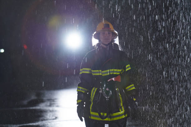 istock A determined female firefighter in a professional uniform striding through the dangerous, rainy night on a daring rescue mission, showcasing her unwavering bravery and commitment to saving lives. 1511333668