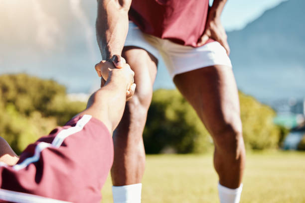 istock Team, helping hand or rugby men in training, exercise or workout in a practice match on sports field. Challenge, strong man or powerful group in tough competitive game with physical fitness or effort 1511334092
