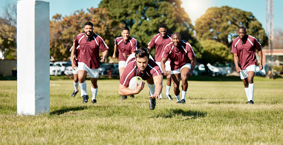 Rugby, team on field and sports game with men, athlete running and player score a try with ball, fitness and active outdoor. Exercise, championship match and teamwork with jump, action and energy
