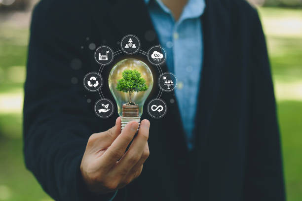 istock Businessman holding a light bulb with a tree growing from money with environment icons. Saving money and finances and Green business growth, Eco business investment.carbon credit. profit and success. 1511351843