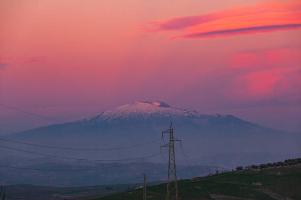The majestic Etna volcano at sunset seen from central Sicily on pink sky