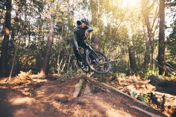 istock Cycling trick, speed and man on a bicycle on a dirt forest road doing training and exercise on a bike. Fast, outdoor trail and biker athlete with cardio and energy on a biking adventure with jump 1511390137