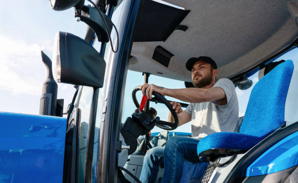 istock Tractor driver in sitting in agriculture tractor cabin. 1511396107