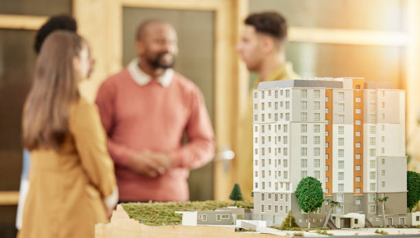 istock Architecture team, meeting and city model in office for construction agency, development or strategy. Business people, architect teamwork and 3d prototype of buildings, property and mock up space 1511396674