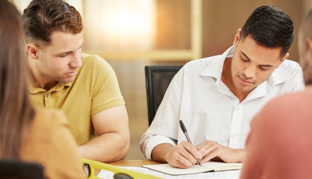 istock Business, people and team writing in notebook for meeting, planning and project collaboration in office. Man, group and diary of ideas for schedule, paperwork and research of brainstorming together 1511396746