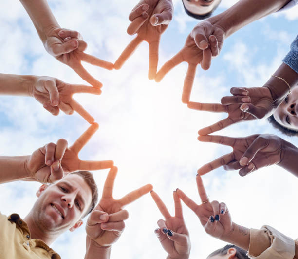 istock Hands, star and low angle circle for business people with icon for motivation, support and goals by sky. Businessman, women and solidarity for diversity, synergy and progress with teamwork at company 1511396879
