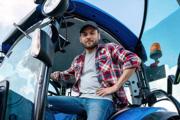 istock Low view portrait of tractor driver smiling and looking at camera. 1511400148
