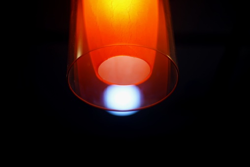 A closeup shot of a glowing lamp in the dark with a blurred background