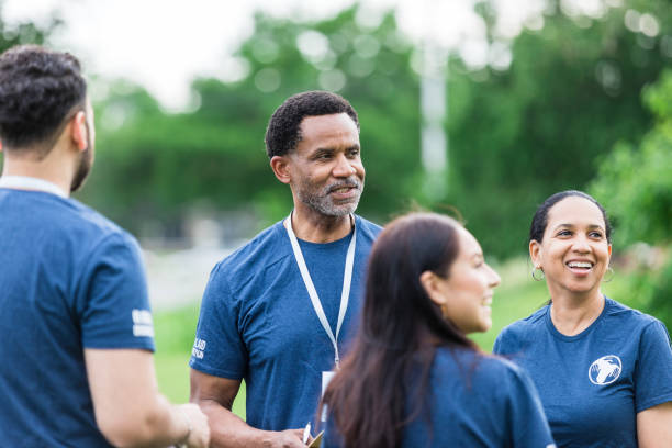 istock Diverse group of coworkers take a break while volunteering at the park 1511406727
