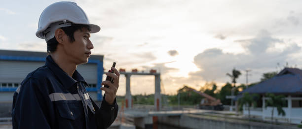 istock maintenance and inspector. Maintenance engineers are using walky talky to inform the results of inspection of buildings and structures. Irrigation engineers are exploring sluice systems 1511407288