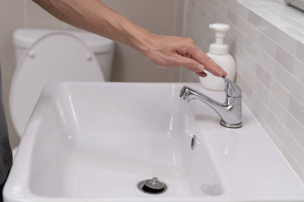 istock Save water. Man keeps turning off the running water in the bathroom to protect environment. Greening planet, reduce global warming, Save world, life, future, risk energy, crisis , water day. 1511408100