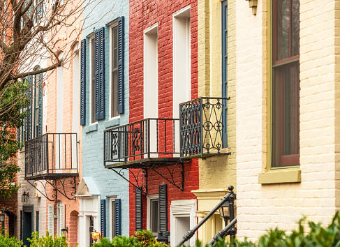 The exteriors of a row of properties in Capitol Hill, Washington DC, painted in the typical colors of the district.
