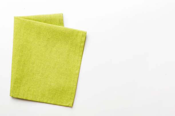 istock top view with green kitchen napkin isolated on table background. Folded cloth for mockup with copy space, Flat lay. Minimal style 1511420593