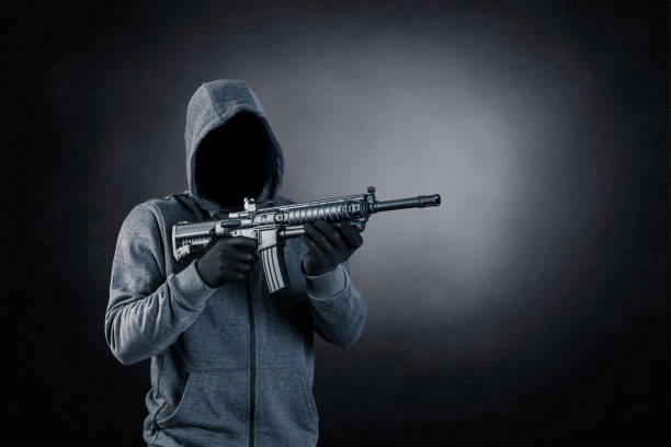 istock Hooded man with assault rifle over dark misty background 1511428309