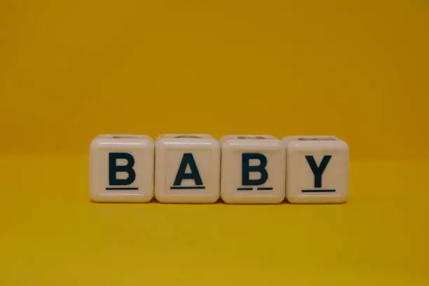 Baby letter blocks on yellow background
